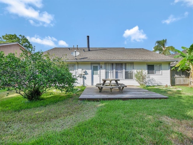 rear view of house featuring a wooden deck and a yard