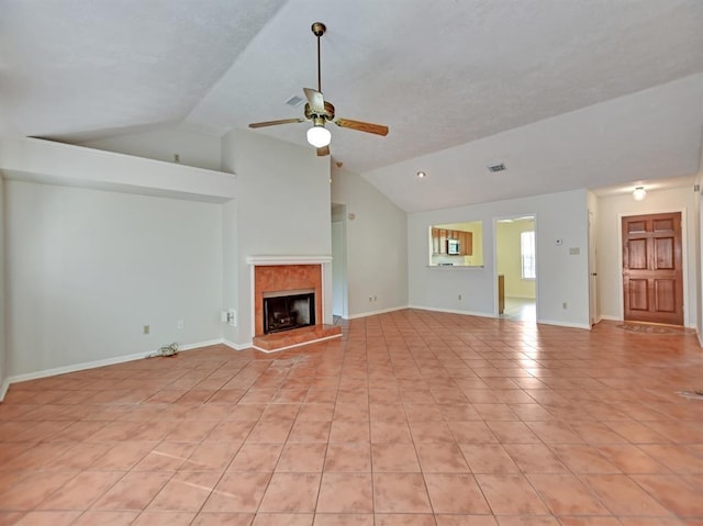 unfurnished living room featuring light tile patterned floors, a ceiling fan, baseboards, vaulted ceiling, and a tiled fireplace