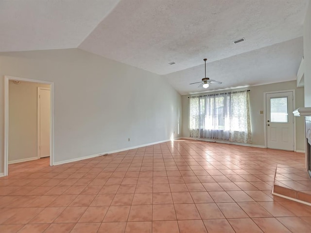 spare room with ceiling fan, light tile patterned floors, a textured ceiling, visible vents, and vaulted ceiling