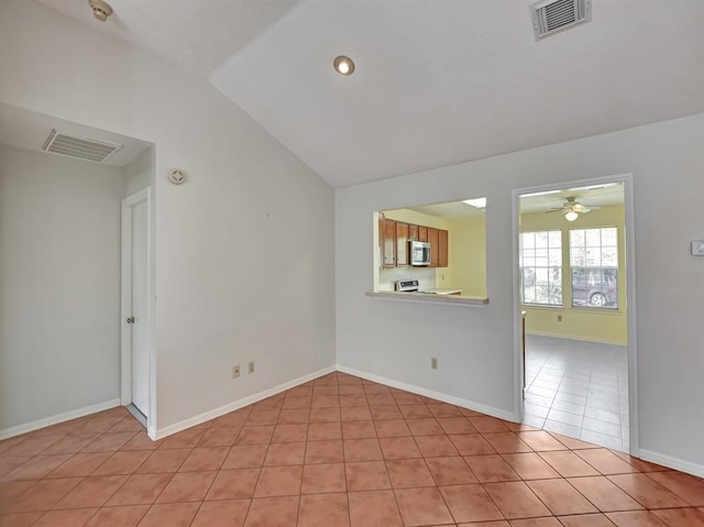 unfurnished room featuring lofted ceiling, visible vents, baseboards, and light tile patterned floors