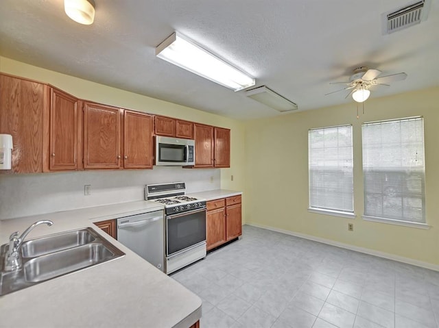 kitchen with stainless steel appliances, light countertops, a sink, and visible vents