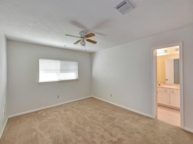 spare room featuring baseboards, ceiling fan, visible vents, and light colored carpet