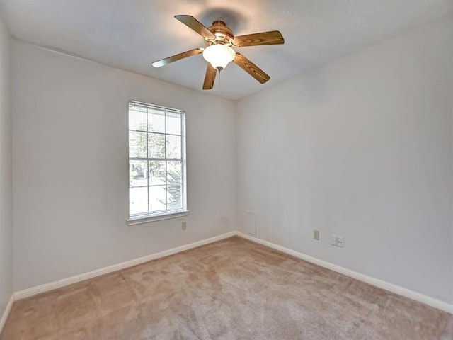 unfurnished room with ceiling fan, baseboards, and light colored carpet