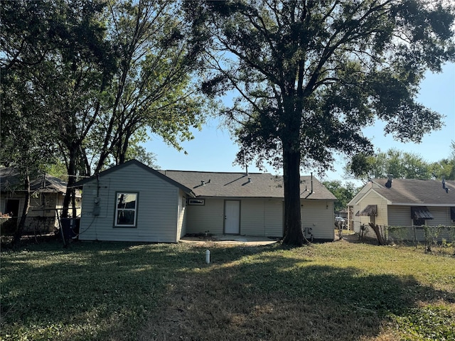 rear view of property with a yard and fence