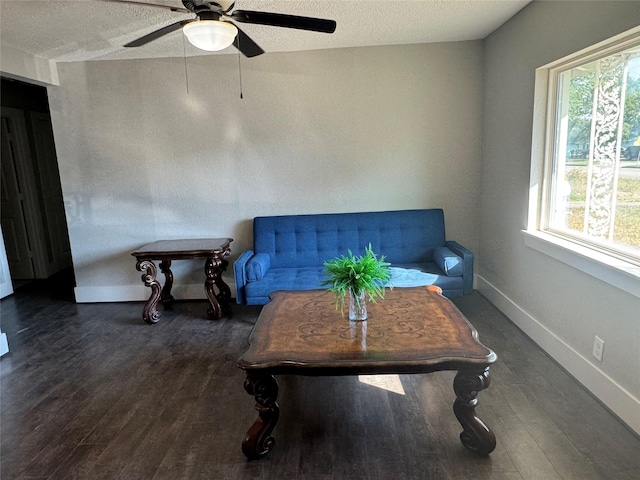 sitting room with a textured ceiling, dark wood-type flooring, and ceiling fan