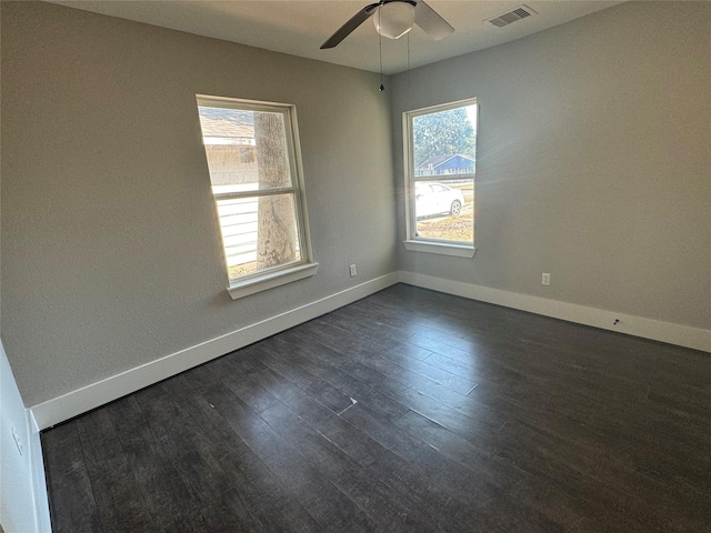 unfurnished room with ceiling fan, a wealth of natural light, and dark hardwood / wood-style flooring