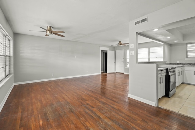 unfurnished living room featuring ceiling fan and light hardwood / wood-style flooring