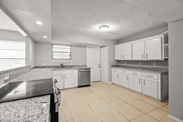 kitchen featuring appliances with stainless steel finishes, sink, light tile patterned floors, and white cabinets