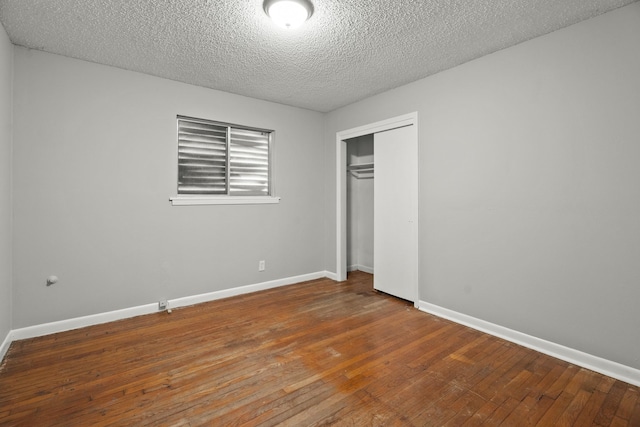 unfurnished bedroom featuring hardwood / wood-style floors, a closet, and a textured ceiling