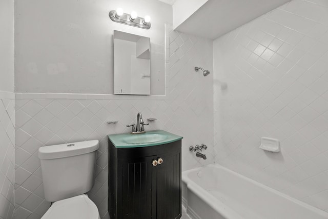 full bathroom featuring vanity, tiled shower / bath, tile walls, and toilet