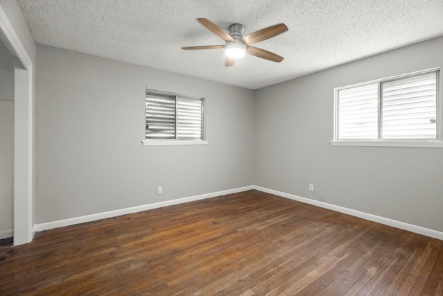 unfurnished bedroom featuring multiple windows, dark wood-type flooring, a closet, and a textured ceiling