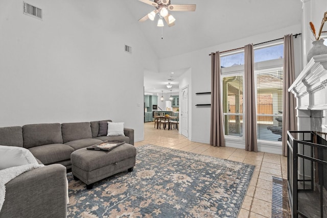 living room with ceiling fan, high vaulted ceiling, and light tile patterned floors