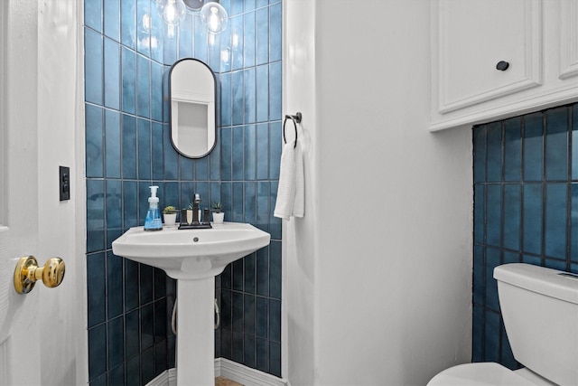 bathroom featuring tile walls and toilet