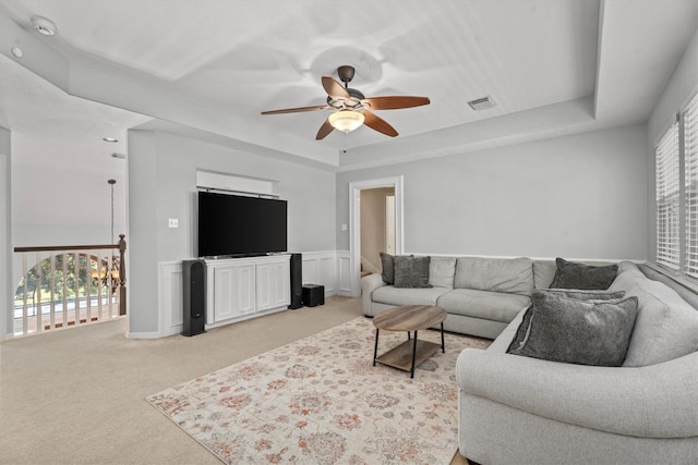 living room with ceiling fan, light colored carpet, a healthy amount of sunlight, and a tray ceiling