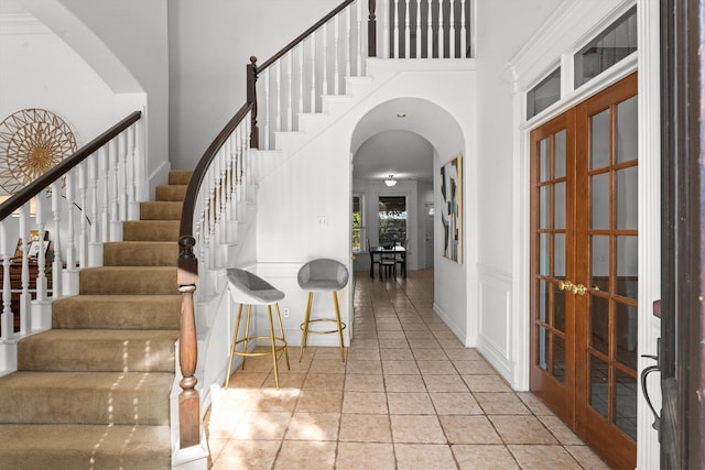 foyer with french doors, a high ceiling, and light tile patterned floors