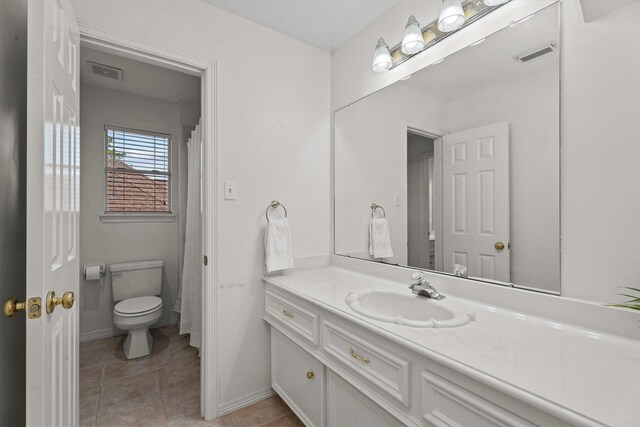 bathroom featuring vanity, tile patterned flooring, and toilet