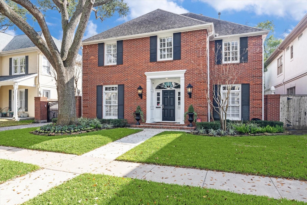 colonial house featuring a front lawn