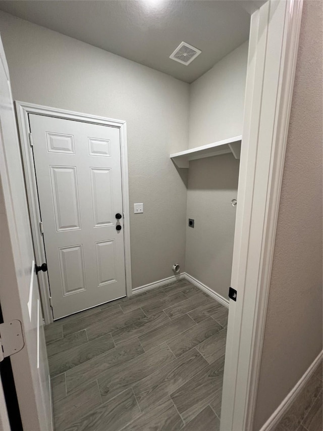 washroom with laundry area, visible vents, baseboards, wood tiled floor, and electric dryer hookup