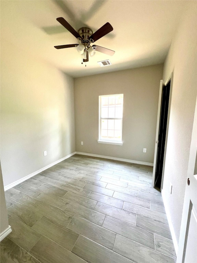 unfurnished room featuring baseboards, visible vents, and wood finished floors