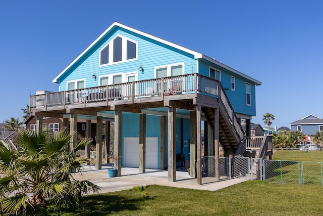 rear view of house with a garage, a wooden deck, and a yard