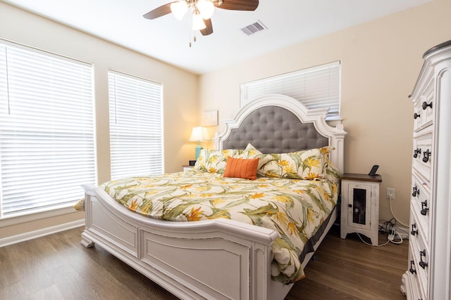 bedroom featuring multiple windows, dark wood-type flooring, and ceiling fan