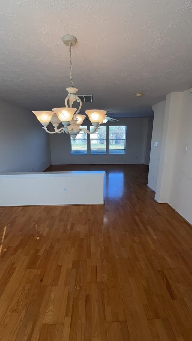 unfurnished dining area featuring dark hardwood / wood-style flooring and a textured ceiling