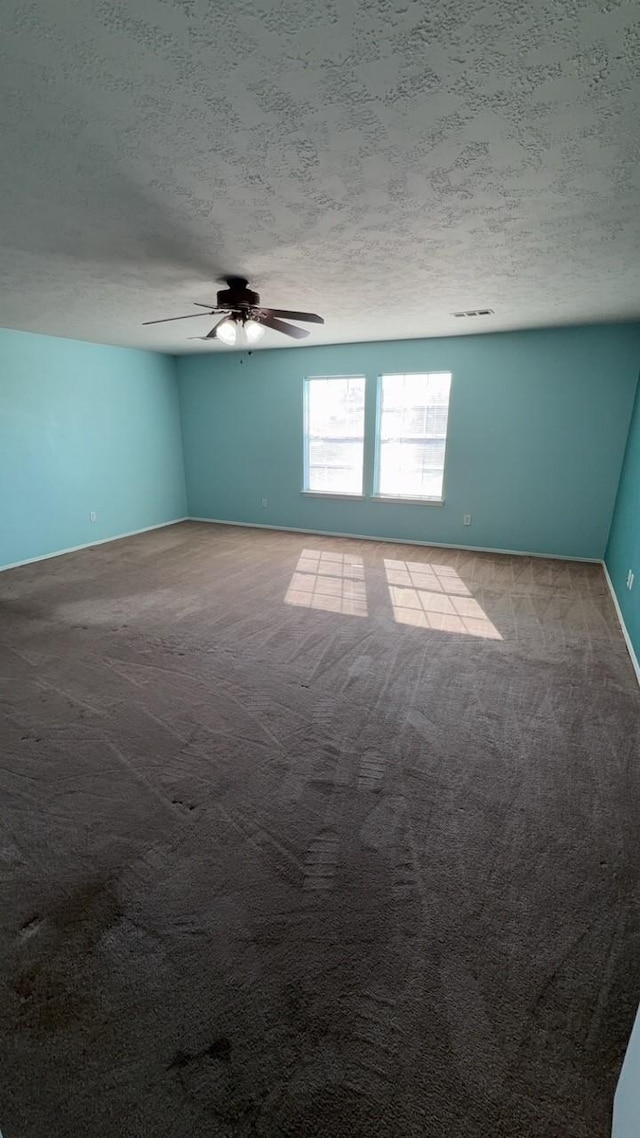 unfurnished room with ceiling fan, light carpet, and a textured ceiling