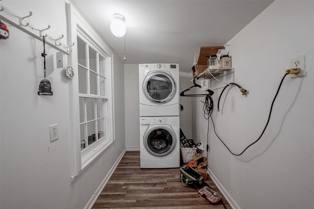 laundry room featuring dark hardwood / wood-style flooring and stacked washer and dryer