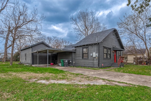 rear view of property featuring a garage, a lawn, and a carport