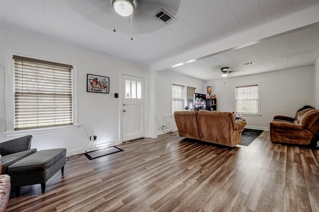 living room featuring hardwood / wood-style flooring, ceiling fan, and beamed ceiling