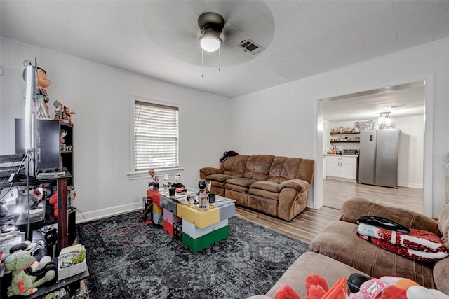 living room with light hardwood / wood-style flooring, ornamental molding, and ceiling fan