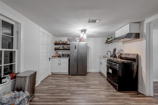 kitchen featuring sink, light hardwood / wood-style flooring, stainless steel refrigerator, white cabinetry, and range with gas stovetop