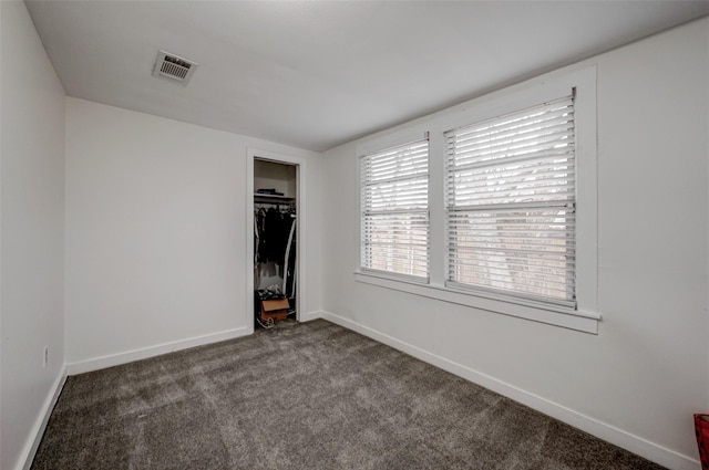 unfurnished bedroom with dark colored carpet