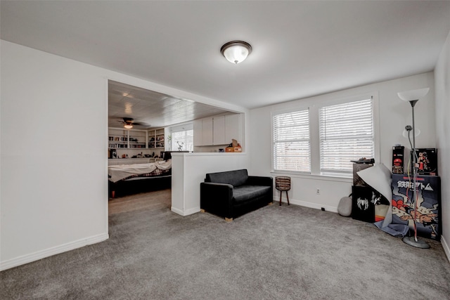 living area featuring ceiling fan, carpet flooring, and a wealth of natural light