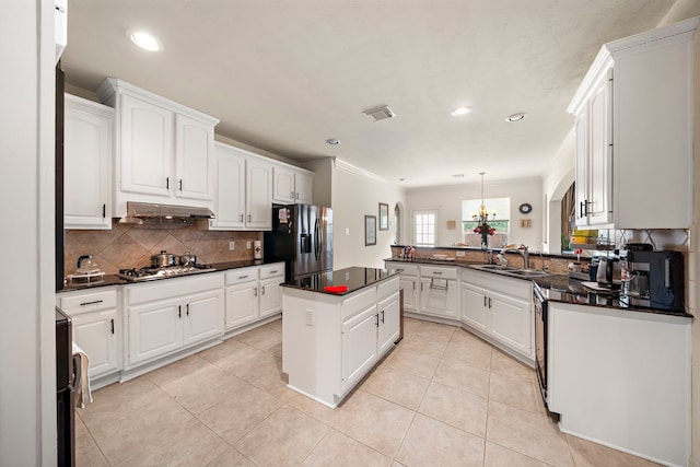 kitchen with white cabinetry, sink, stainless steel appliances, and a kitchen island