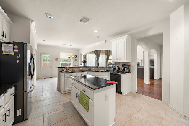 kitchen featuring white cabinetry, a center island, dishwasher, and stainless steel refrigerator with ice dispenser