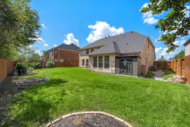 rear view of property with cooling unit, a lawn, and a storage unit