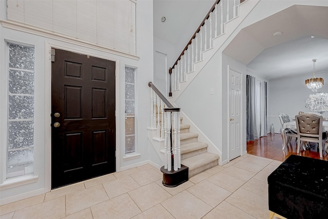 entrance foyer with light tile patterned flooring and a notable chandelier