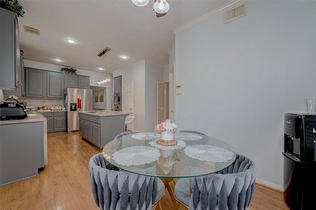 dining area featuring crown molding and light hardwood / wood-style flooring