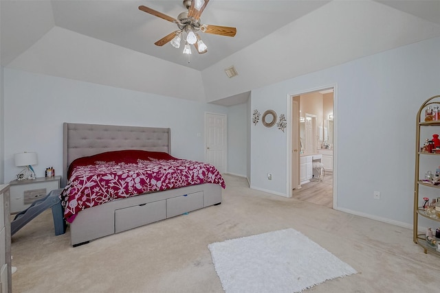 bedroom with ceiling fan, ensuite bathroom, vaulted ceiling, and light carpet