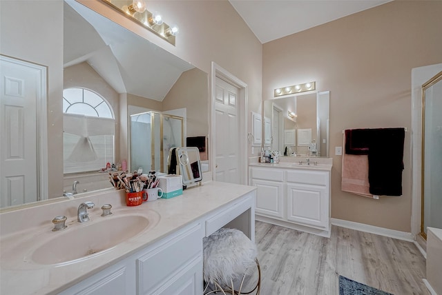 bathroom featuring lofted ceiling, wood-type flooring, a shower with shower door, and vanity