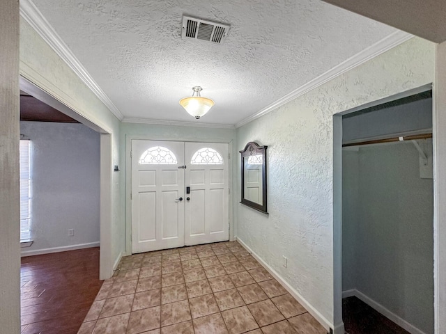 foyer with ornamental molding and a textured ceiling