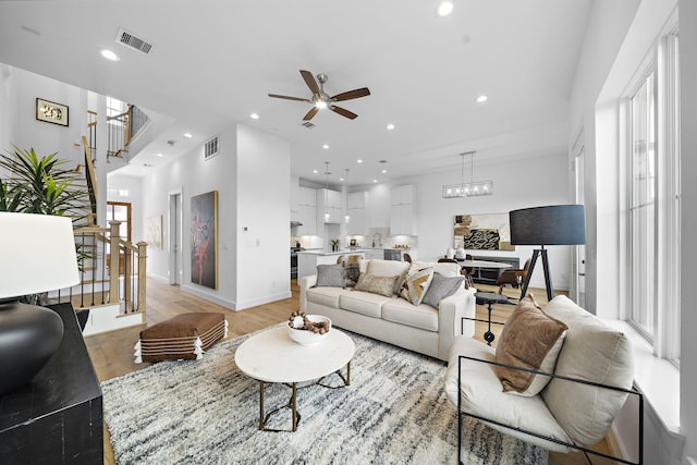 living room featuring ceiling fan and light hardwood / wood-style floors