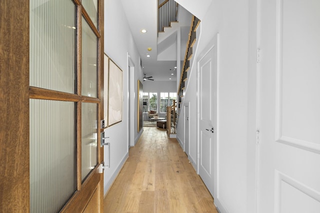 hallway featuring stairway, recessed lighting, and light wood-style floors