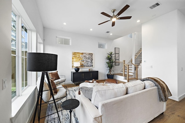 living room featuring visible vents, baseboards, stairs, recessed lighting, and wood finished floors