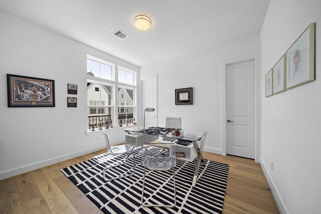 home office featuring light wood-style flooring, baseboards, and visible vents