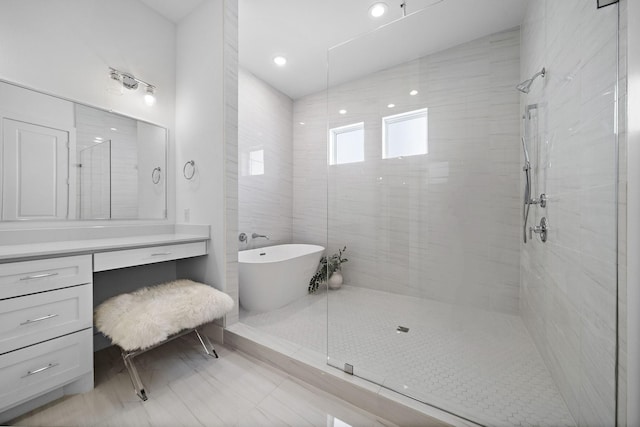 bathroom featuring vanity, a tile shower, and a freestanding bath