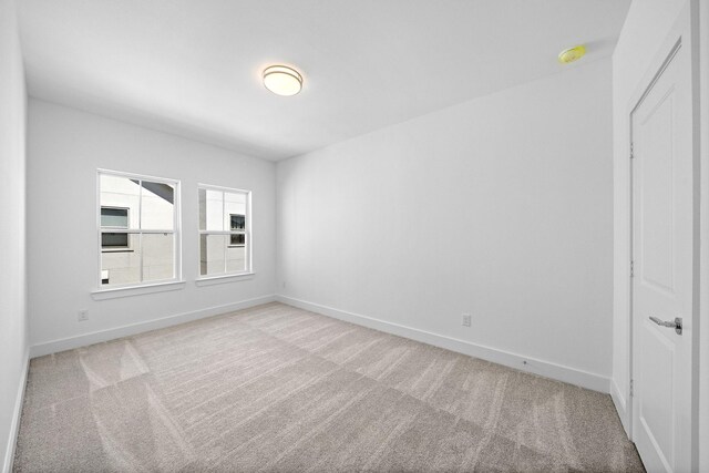 carpeted empty room with baseboards