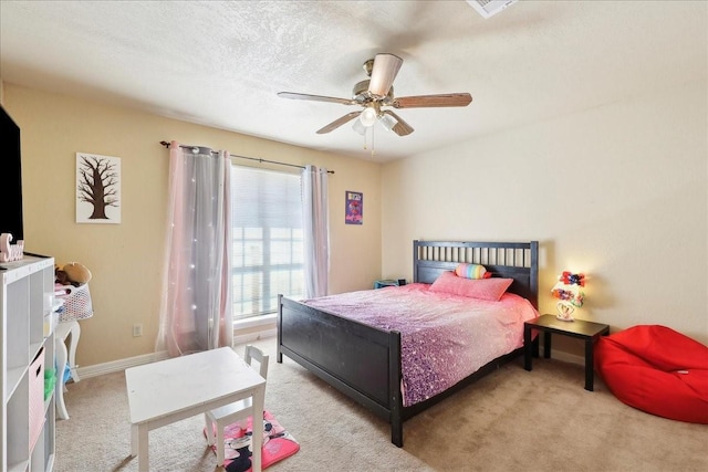 carpeted bedroom with ceiling fan and a textured ceiling