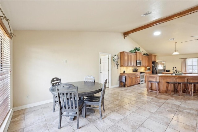 dining area featuring vaulted ceiling with beams, light tile patterned floors, and sink